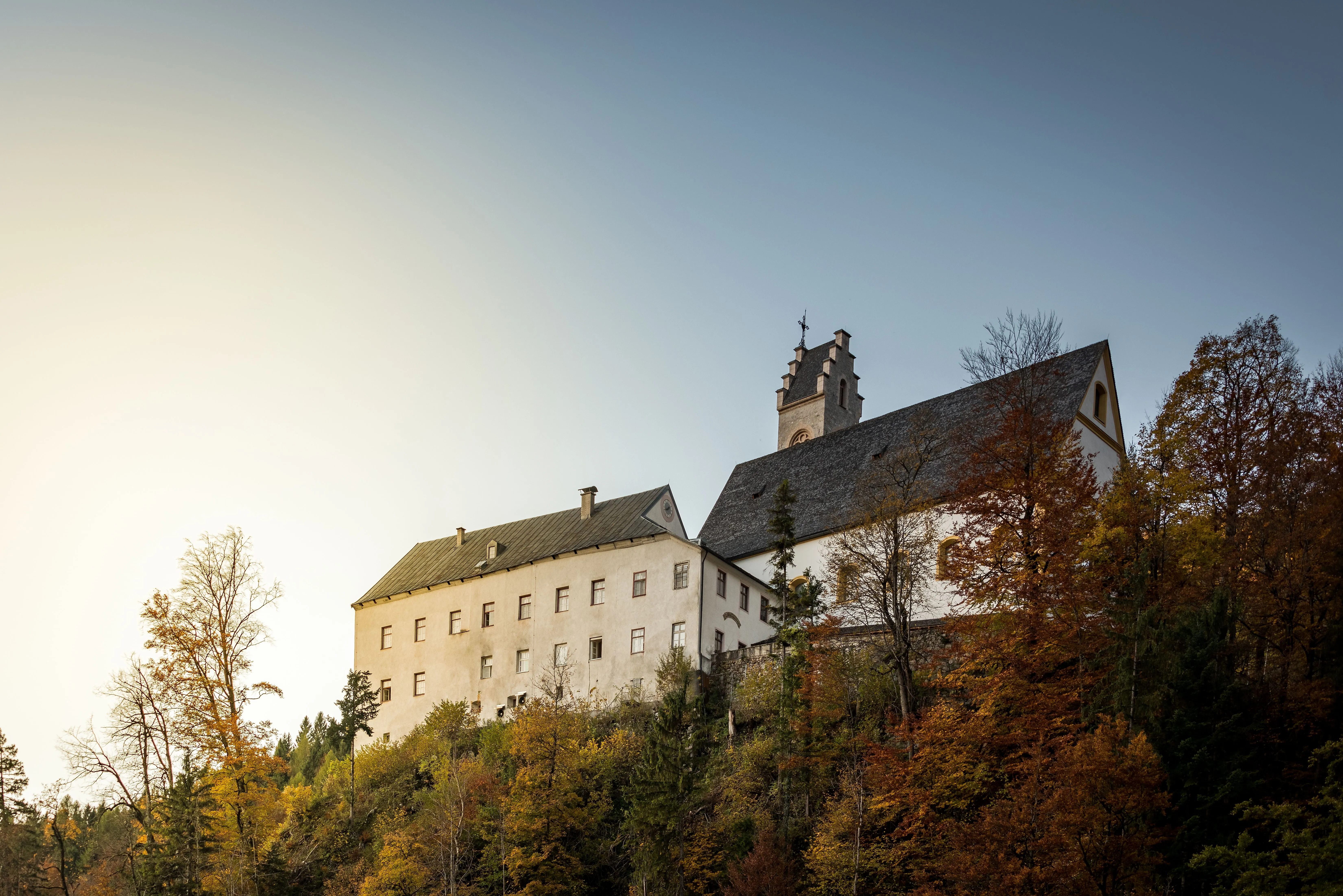 Kloster St. Georgenberg bei Stans auf bewaldetem Hügel im herbstlichen Karwendel