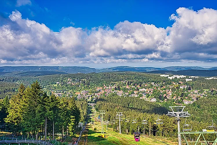Blick vom Bocksberg auf den Ort Hahnenklee im Harz mit Seilbahn und bewaldeten Hügeln