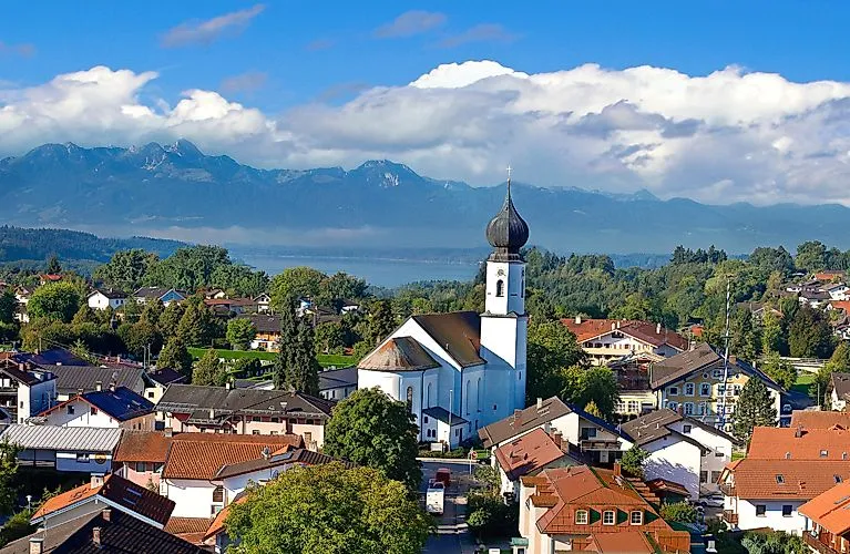 Vista de verano sobre Bad Endorf con la iglesia y el panorama alpino al fondo