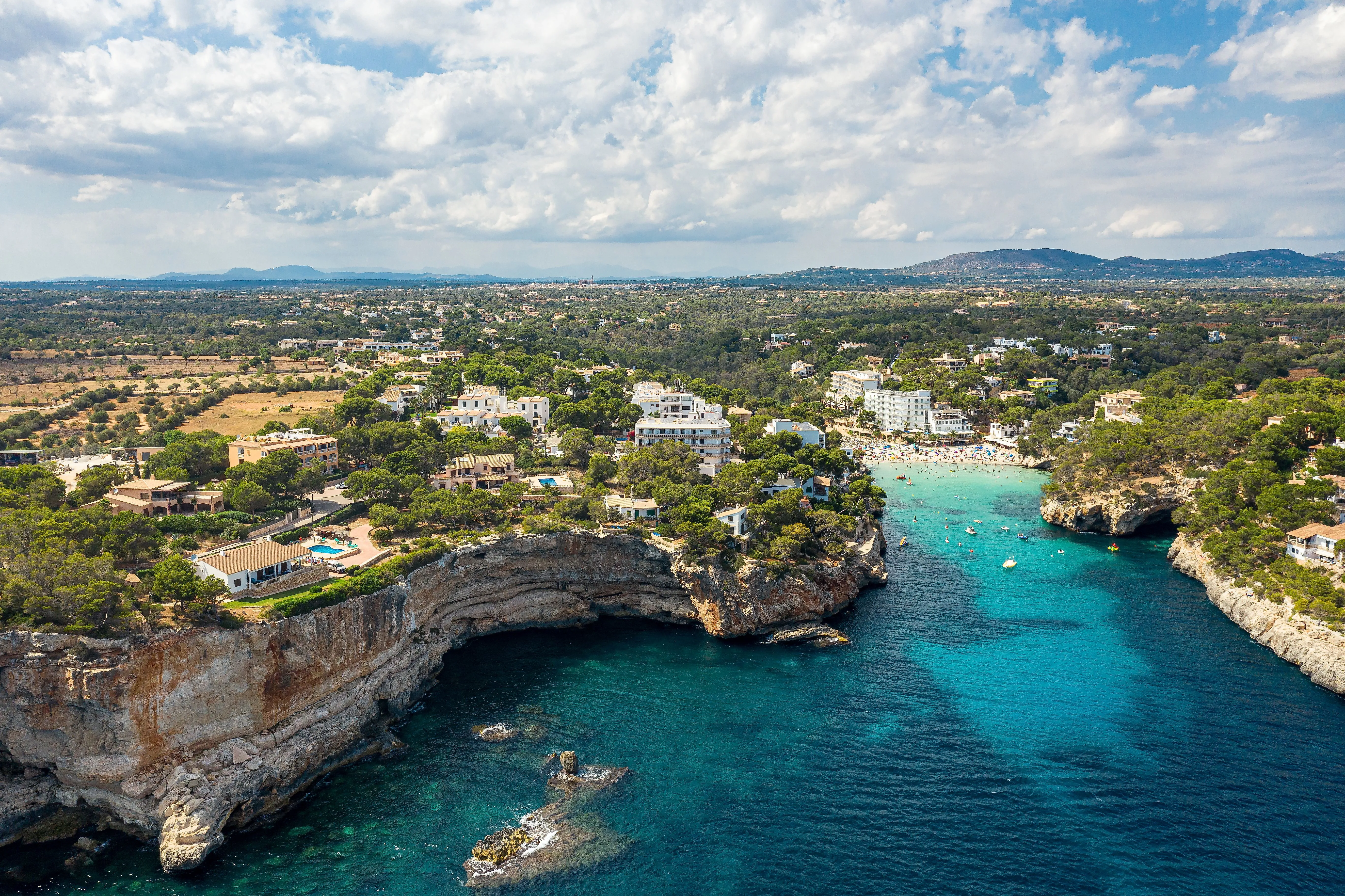 Aerial view of the picturesque bay of Cala Santanyí on Mallorca with turquoise blue water and white coastline.