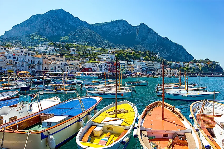 Traditionelle Boote im Hafen von Capri mit Blick auf die Küste und Häuser der Insel