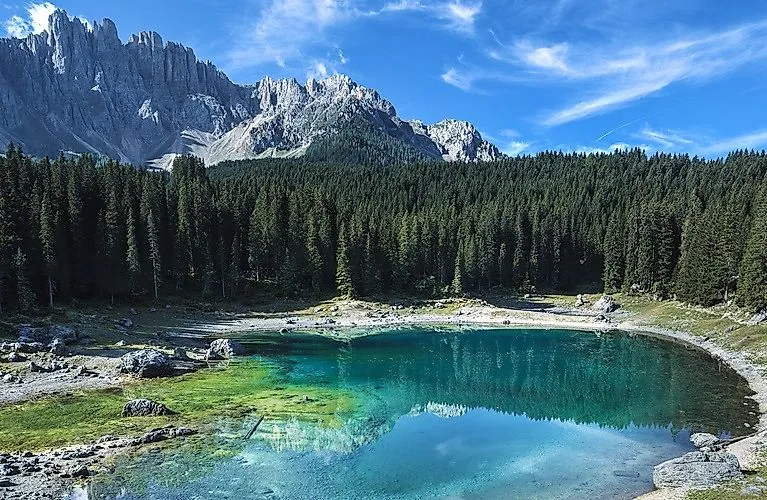 Pohľad na jazero Carezza s Dolomitmi odrážajúcimi sa v priezračnej vode