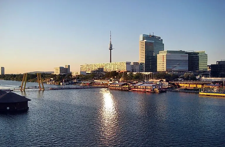 Skyline van Wenen met de Donautoren en de moderne Donaustad aan de oever van de Donau bij zonsondergang.