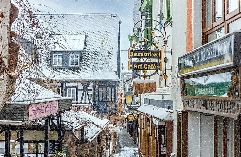 Wintery Drosselgasse in Rüdesheim with snow-covered half-timbered houses and cozy cafés