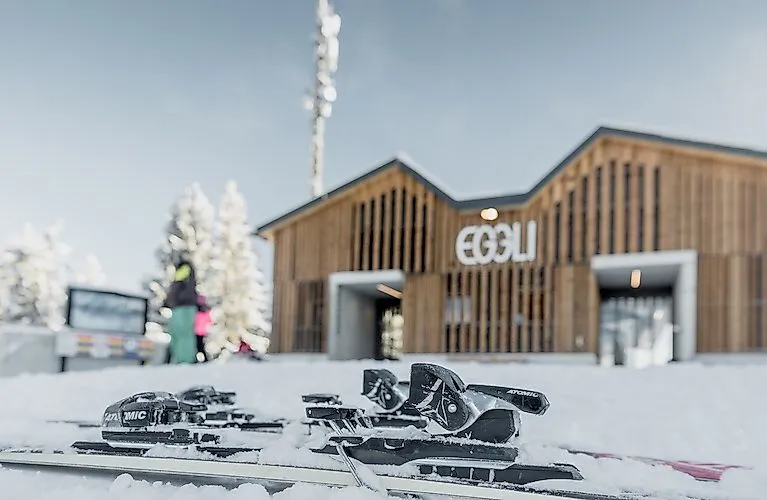 Skiausrüstung vor der modernen Eggli-Bergstation im verschneiten Winterparadies bei Gstaad