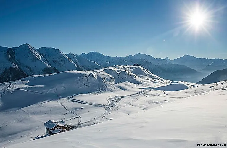 Winter panorama on the Fiescheralp with a view of snow-covered slopes and the mountains of the Aletsch Arena.