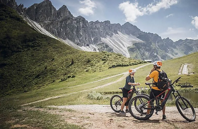 Due mountain biker fanno una pausa davanti a un impressionante scenario roccioso nei pressi di Gossensass, in Alto Adige.