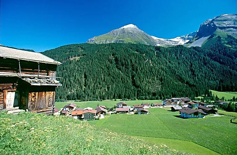 Pohľad na obec Finkenberg v zelenom údolí Zillertal s okolitými horami a lesmi