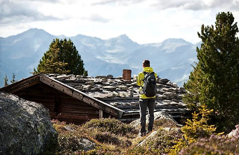 Los excursionistas con mochila disfrutan de las vistas de las montañas circundantes y de un refugio alpino cerca de Fügen.