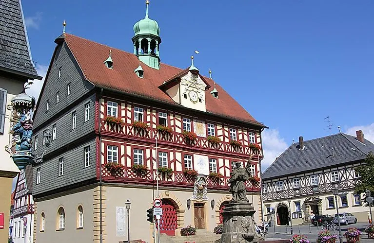 Historická radnice s hrázděnou fasádou a barokním arkýřem ve starém centru města Bad Staffelstein.
