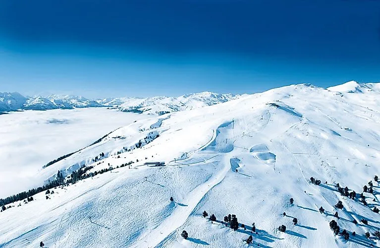 Tief verschneite Hänge im Skigebiet von Gerlos in Tirol mit weiten Pisten und atemberaubender Fernsicht.