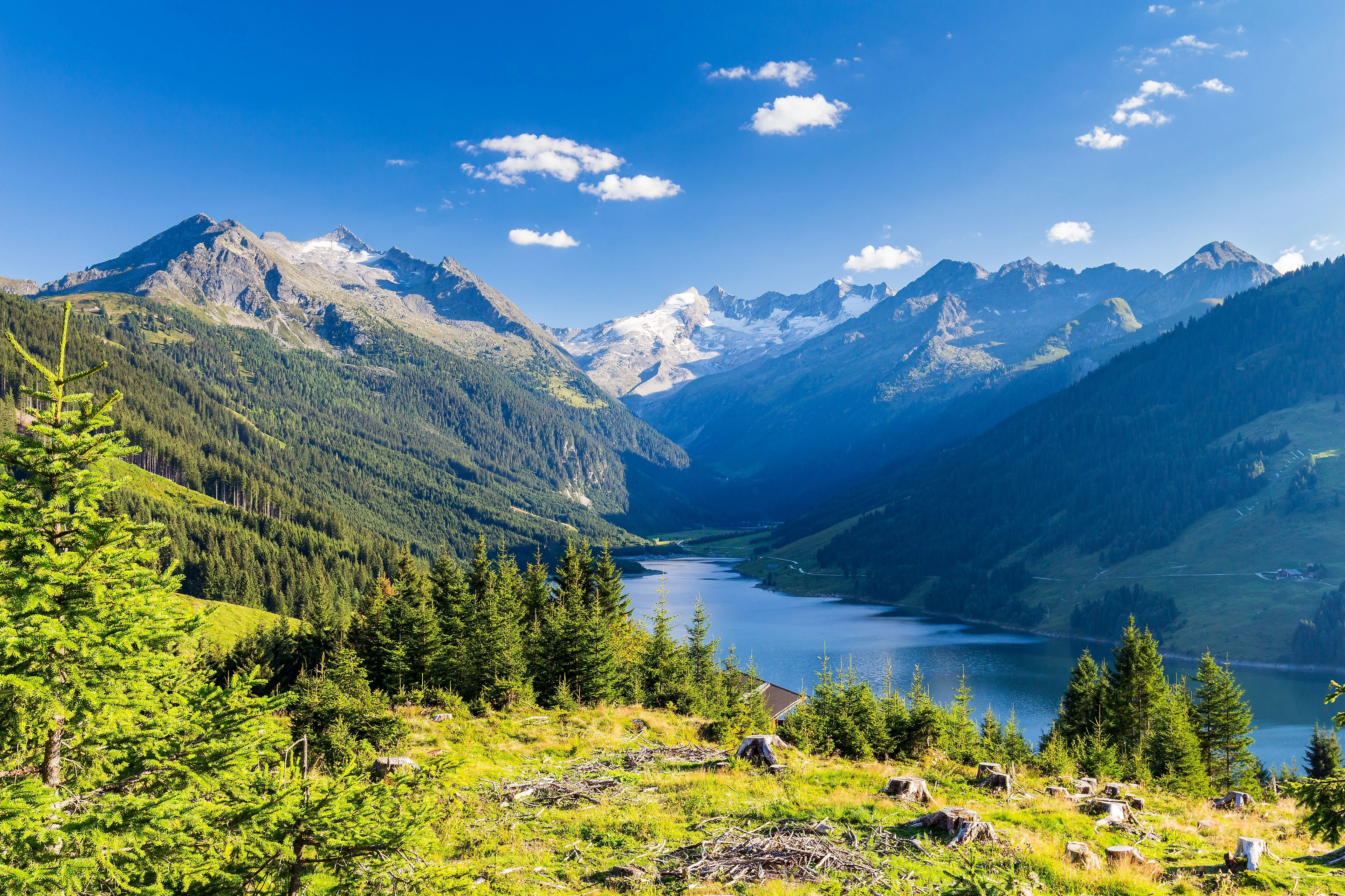 Blick auf den Durlassboden-Speichersee bei Gerlos in Tirol, umgeben von imposanten Bergen und sattgrünen Wäldern.
