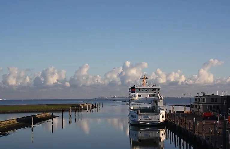Ferry en el puerto de Norden-Norddeich bajo un cielo azul y un mar en calma en un día despejado.