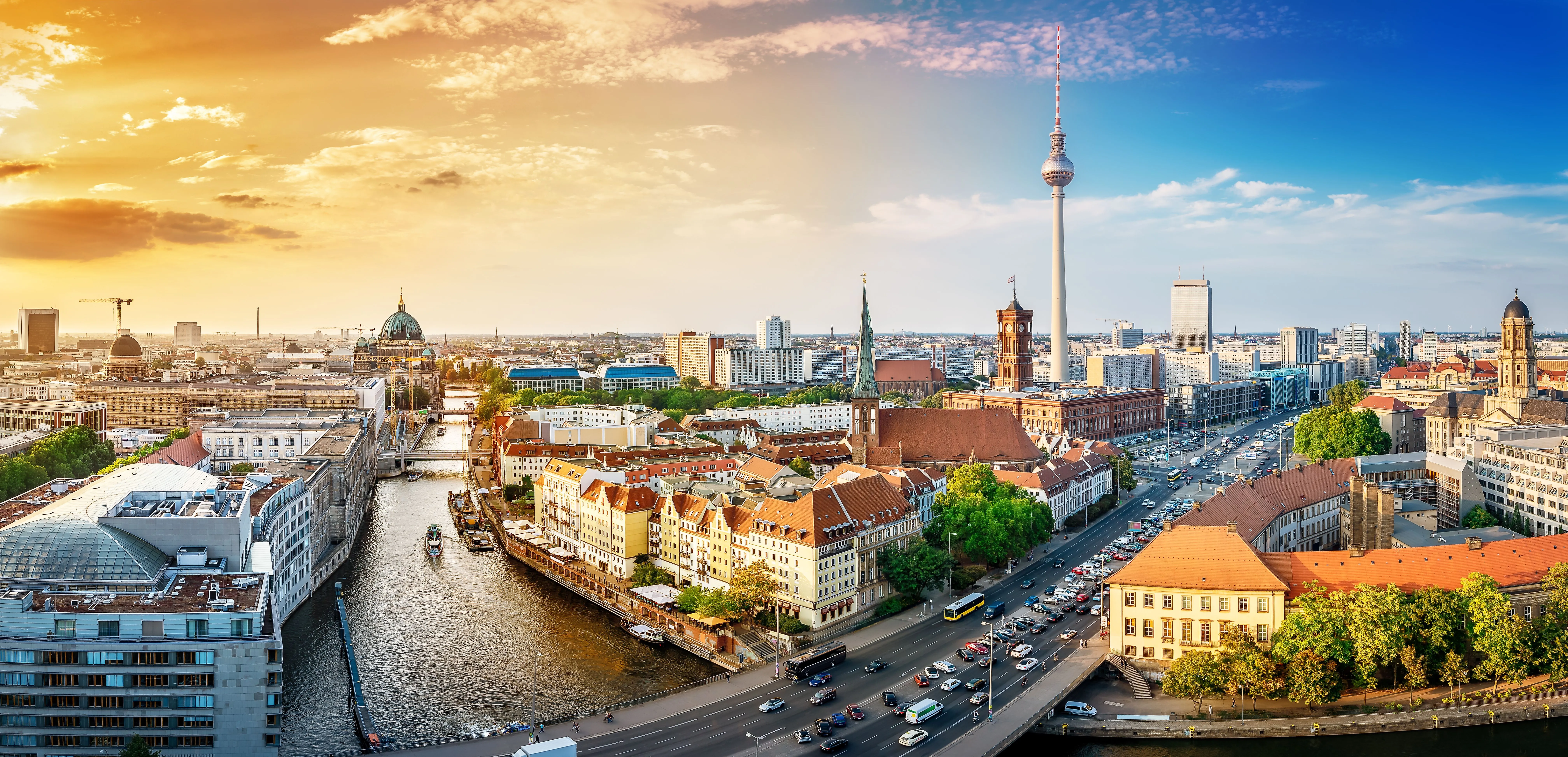 Panoramic view of Berlin featuring the TV Tower, the Spree River, and Berlin Cathedral at sunset