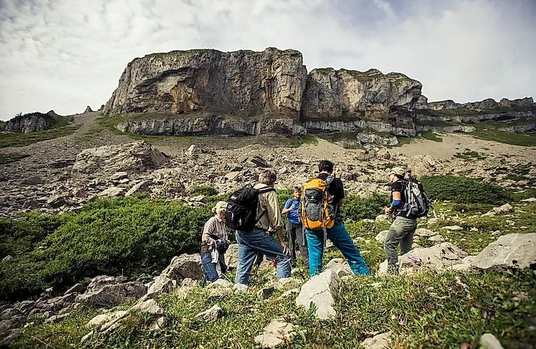 Wandergruppe bei geführter Tour im Kleinwalsertal unterhalb des markanten Ifen-Massivs