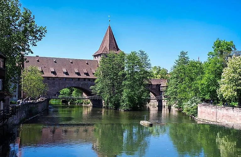 Old bridge with tower over the Pegnitz, surrounded by trees in the old town of Nuremberg.
