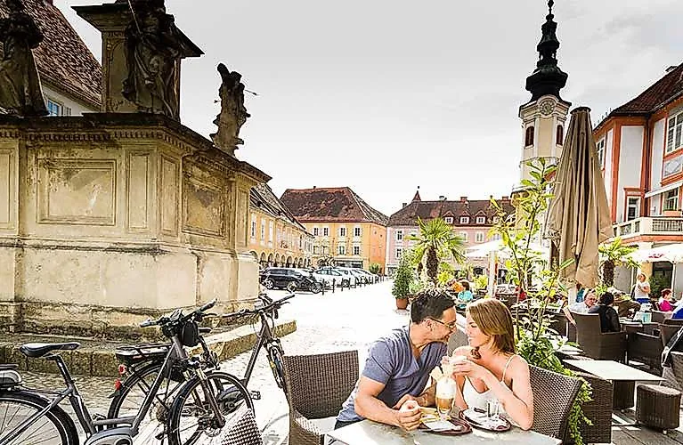 Coppia che prende un caffè nella storica piazza principale di Bad Radkersburg, in Stiria, in estate.