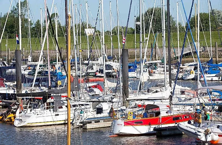 View of the Horumersiel marina with numerous sailing boats and motor yachts in sunny weather