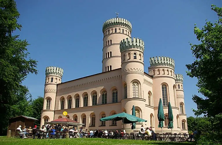 Historický poľovnícky zámok Granitz pri meste Binz na ostrove Rujana s pozoruhodnými okrúhlymi vežami a vonkajším stravovaním počas letného dňa