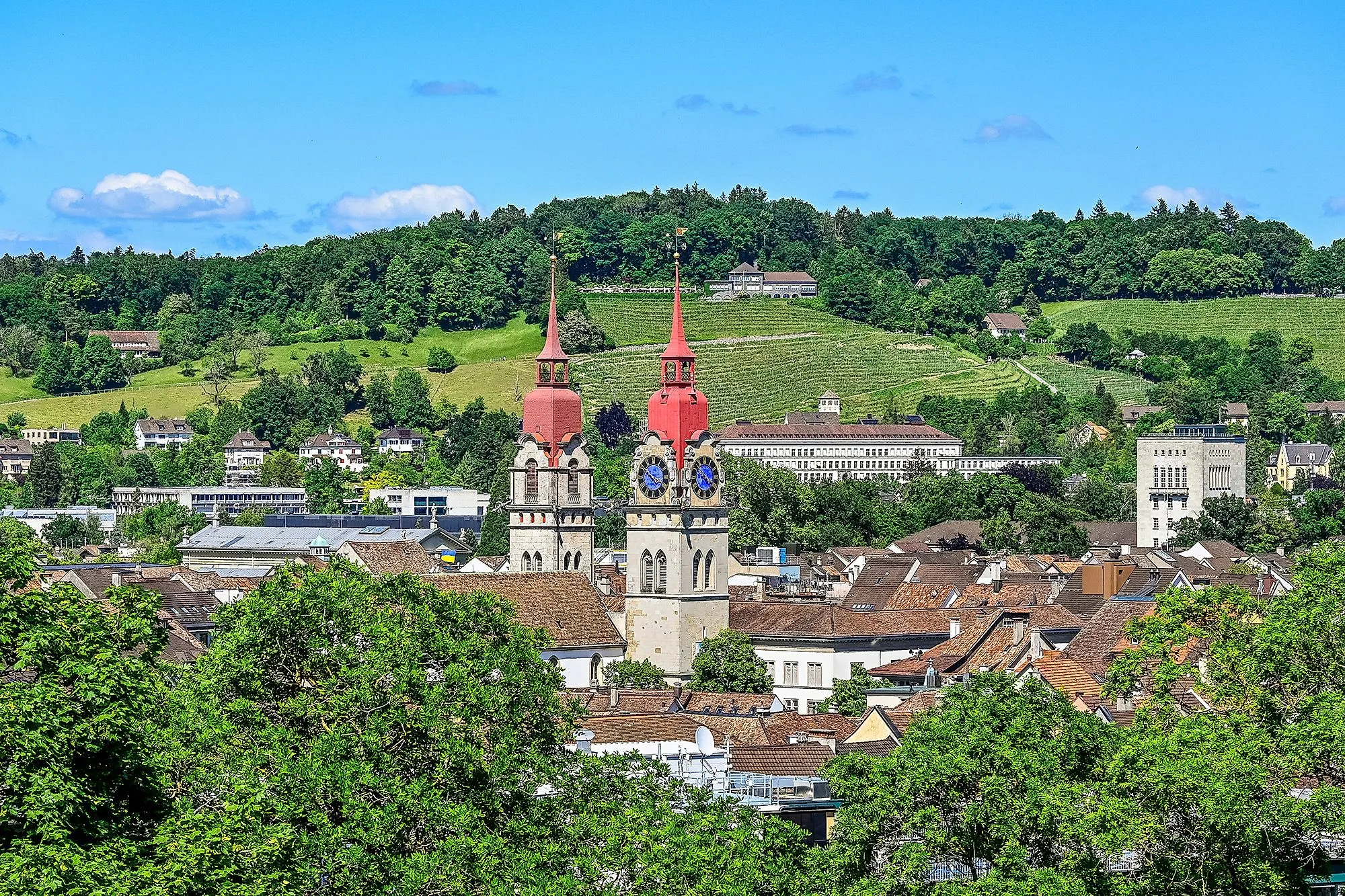 View of Winterthur with the striking red towers of the city church and the green landscape in the background