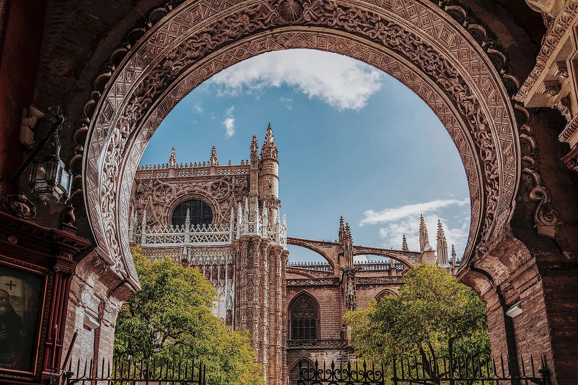Gotische kathedraal van Sevilla met sierlijke boog en blauwe lucht