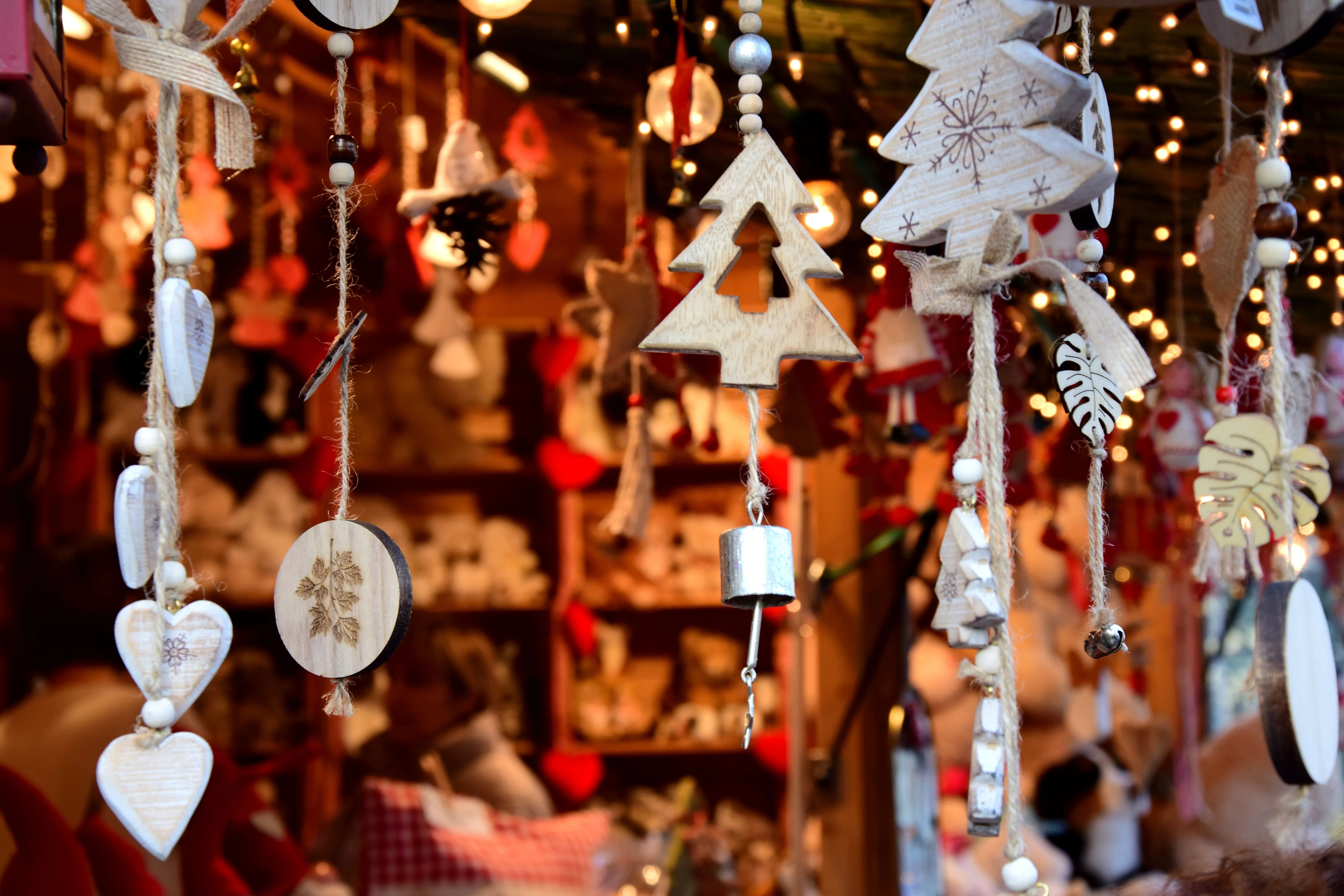 Nahaufnahme handgefertigter Holzdekorationen auf dem stimmungsvollen Weihnachtsmarkt in Meran.