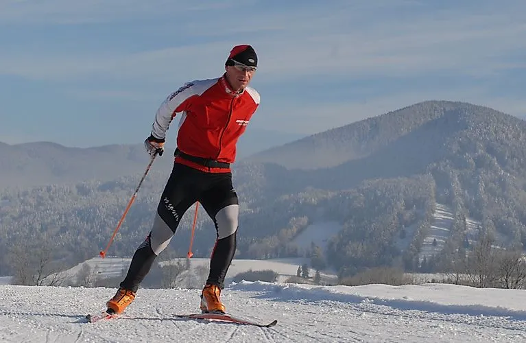 Des skieurs de fond en rouge sur une piste enneigée près de Bad Tölz, dans un décor hivernal boisé.