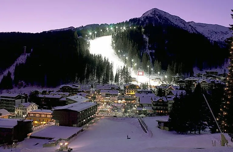 An illuminated ski slope at night in Madonna di Campiglio in Italy. 