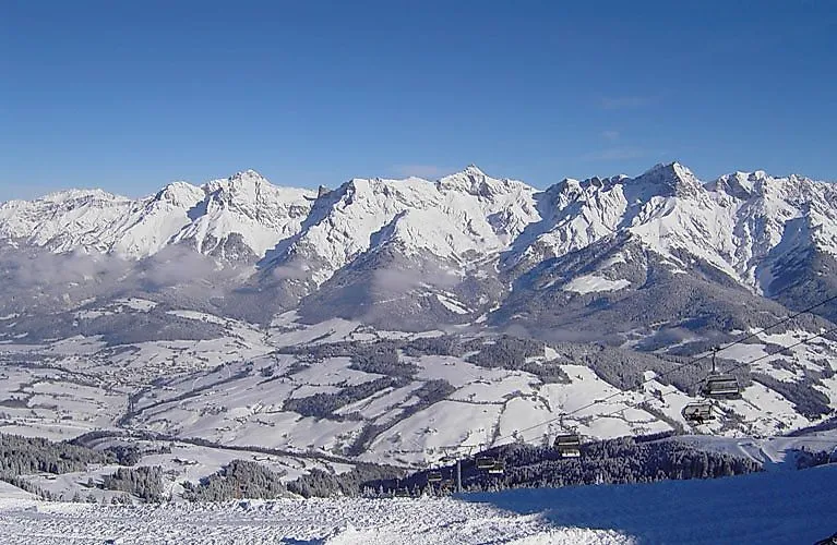 Pohled na zasněžený lyžařský areál Hochkönig se sedačkovými lanovkami a alpským panoramatem