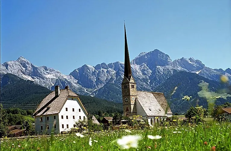 Historický kostel Maria Alm před impozantním masivem Hochkönig v létě