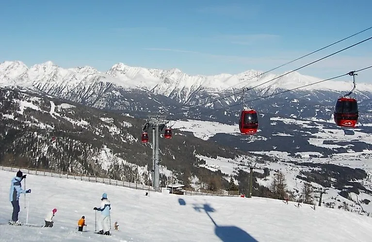 Lyžaři a červené gondoly Lyžařská oblast Grosseck-Speiereck v regionu Mauterndorf