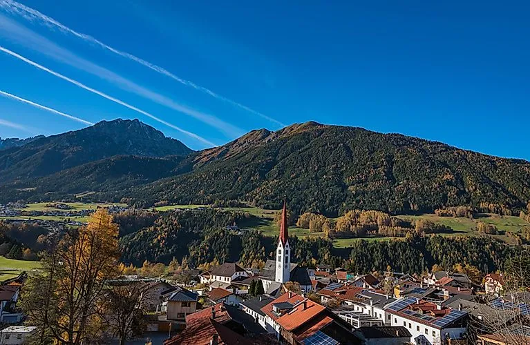 Pohled na Mieders v údolí Stubai s pozoruhodným kostelem a Stubaiskými Alpami v pozadí
