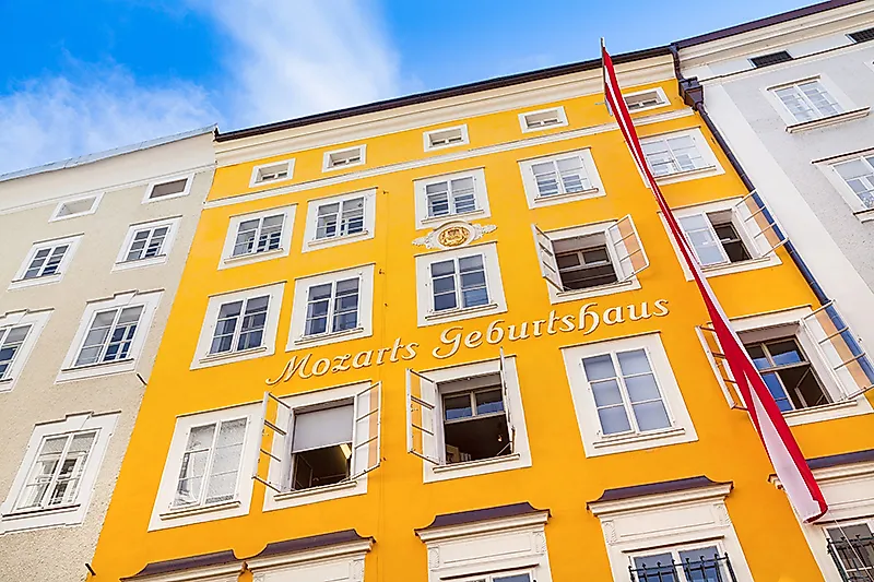 Mozarts Geburtshaus in Salzburg mit gelber Fassade und österreichischer Flagge in der Altstadt