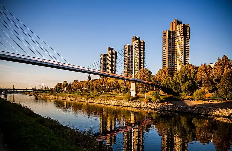 Neckar rivieroever in Mannheim met Collini Centrum en moderne brug bij zonsondergang