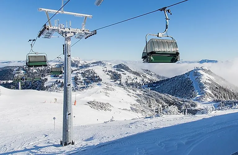 Sedačková lanovka v lyžařské oblasti Hochkar se zasněženými horami a sjezdovkami v Dolním Rakousku