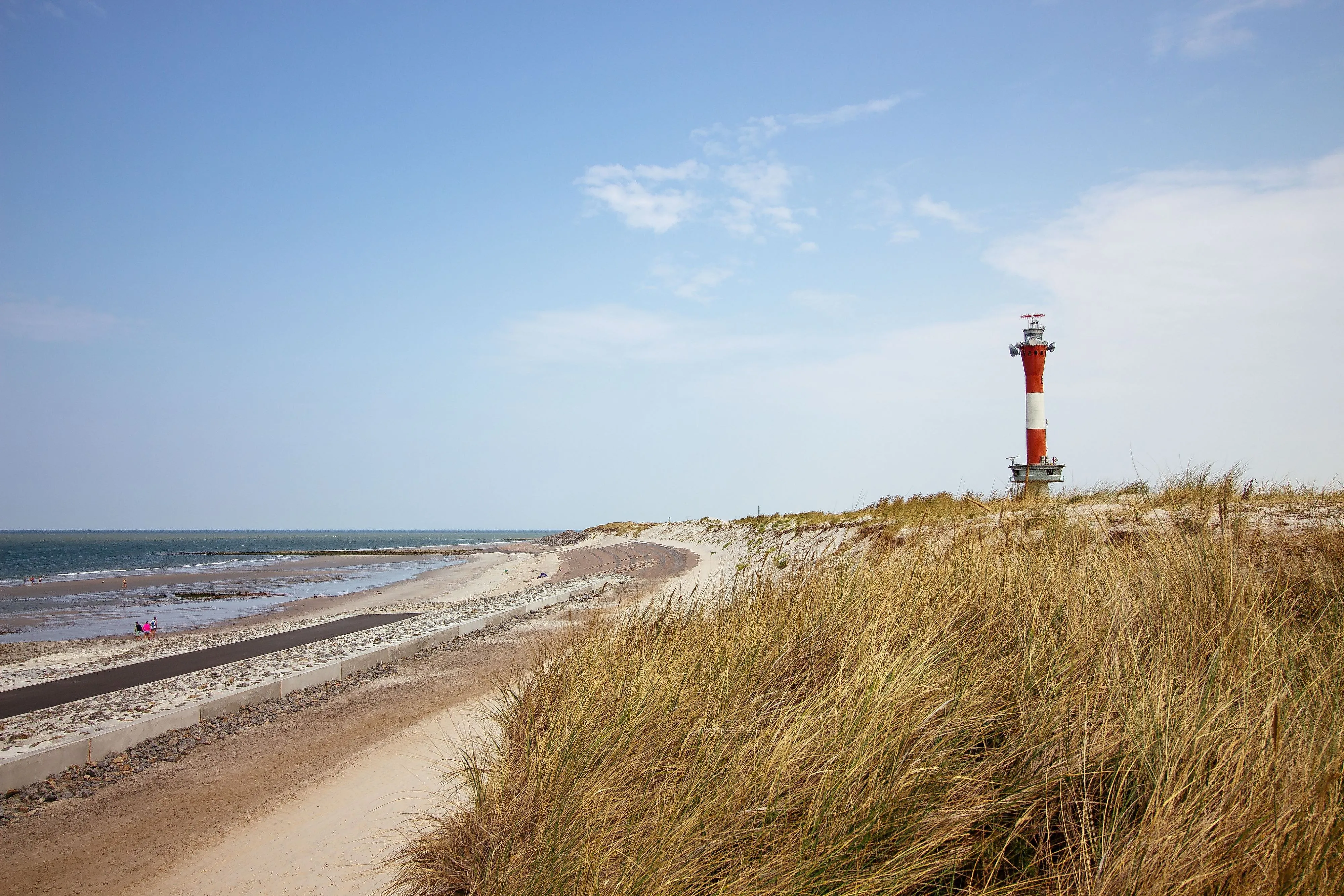 Vuurtoren op Wangerooge achter duinen met uitzicht op het strand en de Noordzee