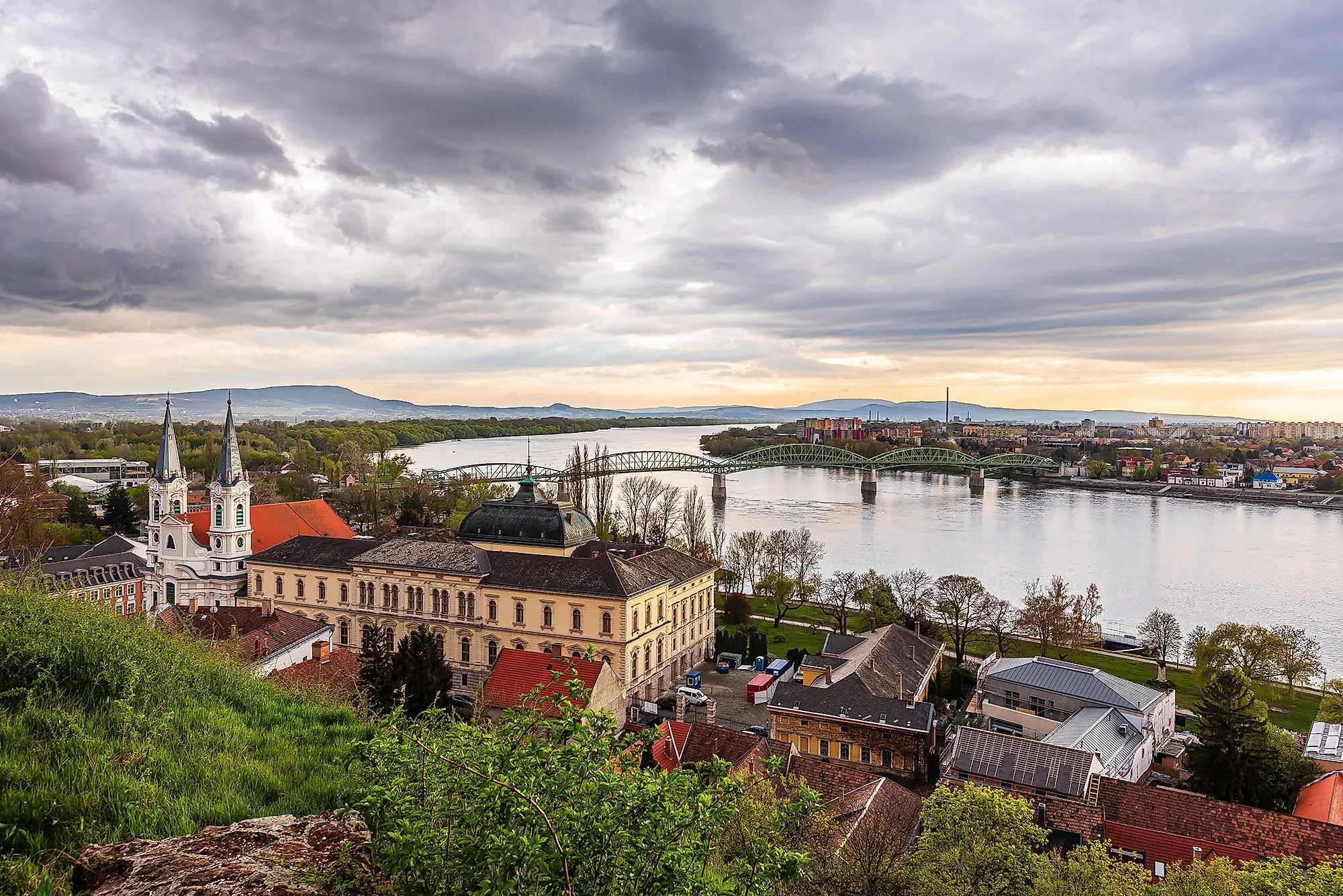 Štúrovo sulle rive del Danubio con il ponte di Esztergom sullo sfondo, sotto un cielo suggestivo