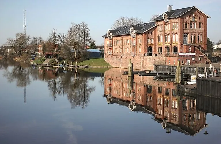 Historic customs house at the harbor from the north with reflection in the calm water of the canal.