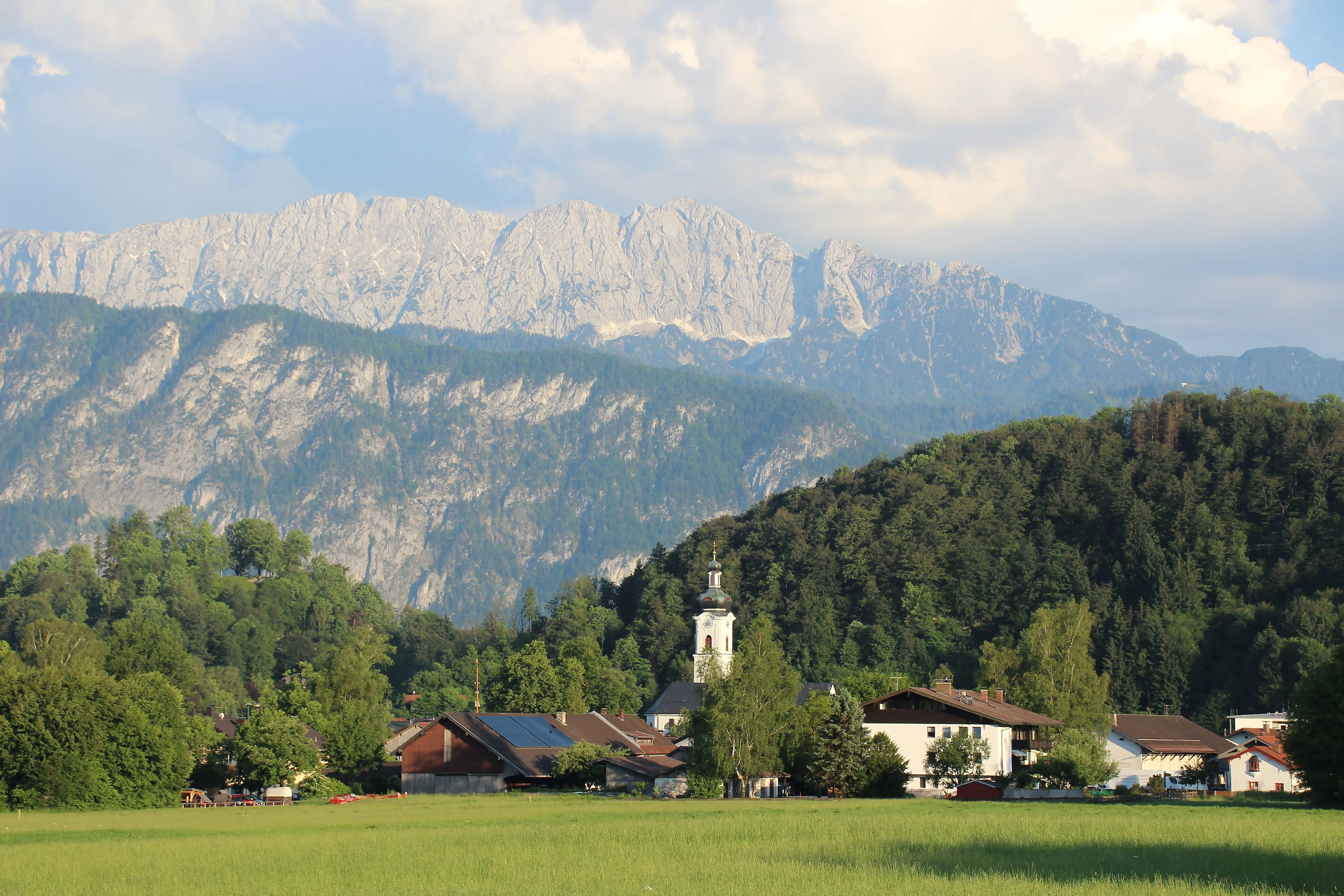 Dorf Oberaudorf mit Kirche und Blick auf das imposante Kaisergebirge im Hintergrund
