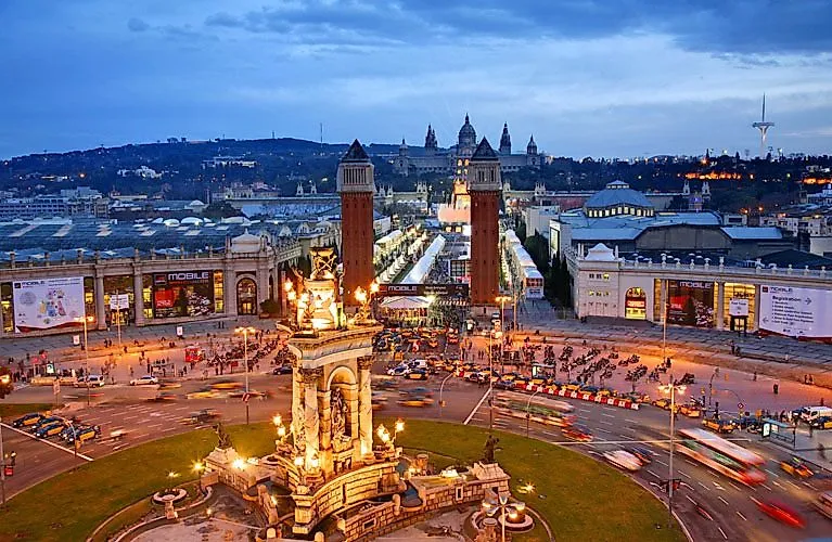 Vista de la animada Plaça d'Espanya de Barcelona con las torres venecianas y el Palau Nacional al fondo