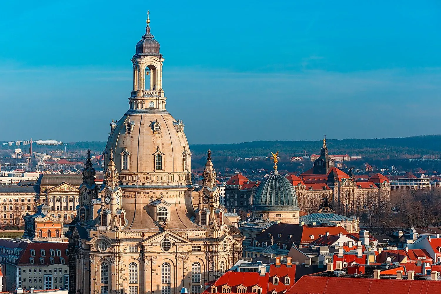 Detail barokního kostela Frauenkirche Dresden pod jasnou oblohou s výhledem na okolní střechy a kopule starého města