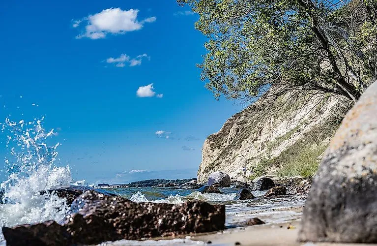 Vlny sa rozbíjajú o skaly na nedotknutých útesoch Mönchgutu na ostrove Rujana.