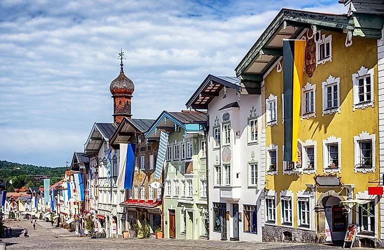 Façades colorées des maisons de la vieille ville de Bad Tölz en été avec des drapeaux bleus et blancs.