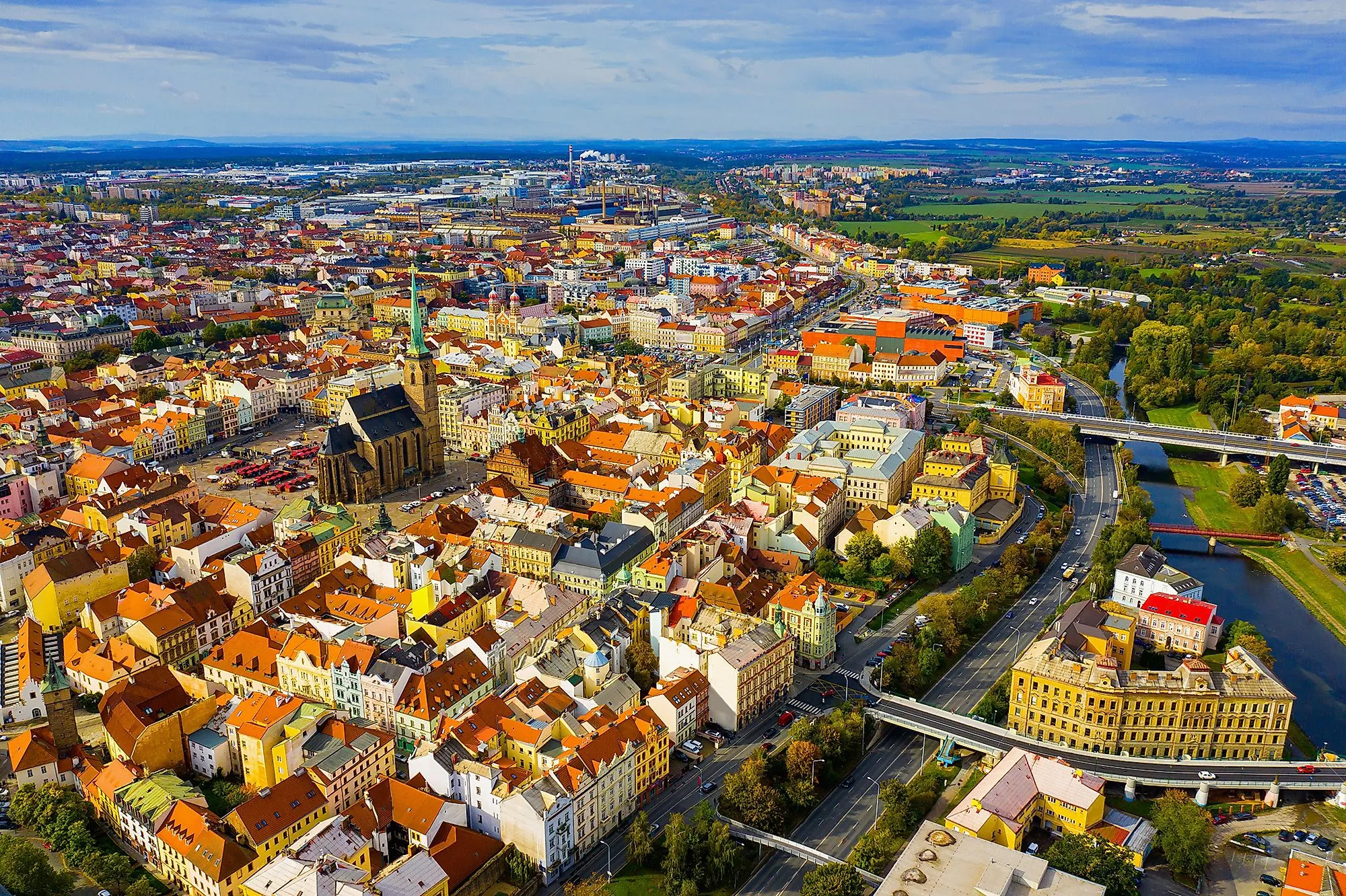 Luftaufnahme von Pilsen mit der St.-Bartholomäus-Kathedrale und bunten Häusern der Altstadt.