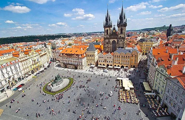 Uitzicht op het Oude Stadsplein in Praag met de Teyn Kerk en kleurrijke historische gebouwen in de zon