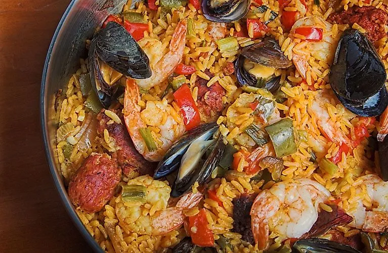 Paella tradicional española con marisco, verduras y arroz