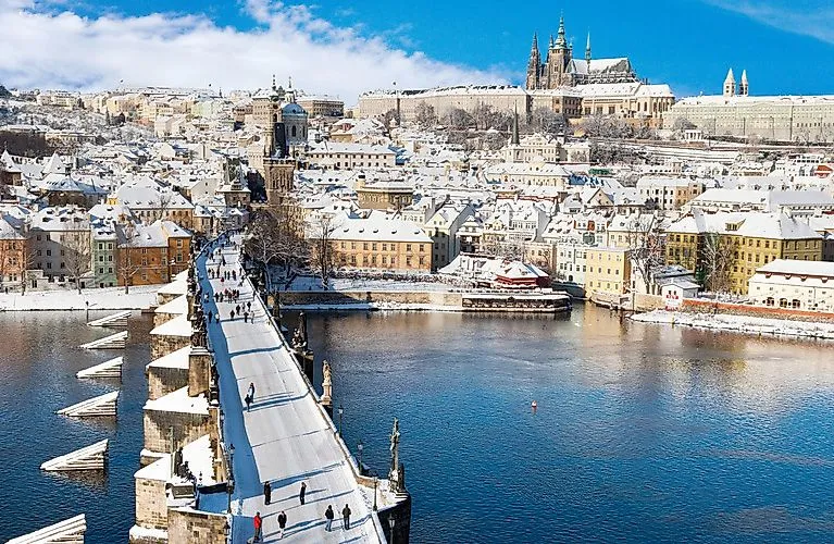 Besneeuwde Karelsbrug in Praag met uitzicht op de Praagse Burcht en de Oude Stad in de winter