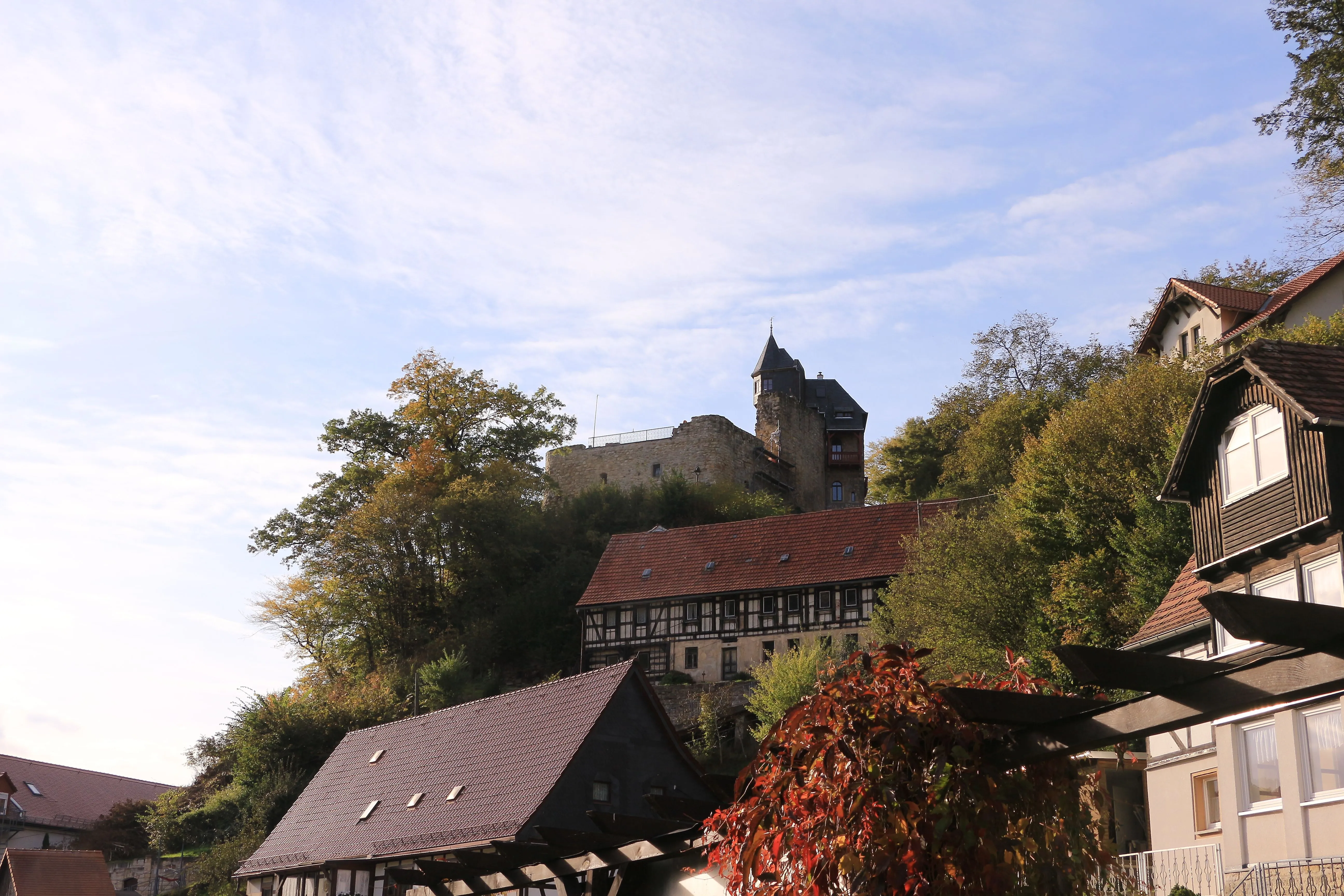 Het historische kasteel Altrathen torent boven de daken van Rathen uit en wordt omringd door herfstkleurige bossen.