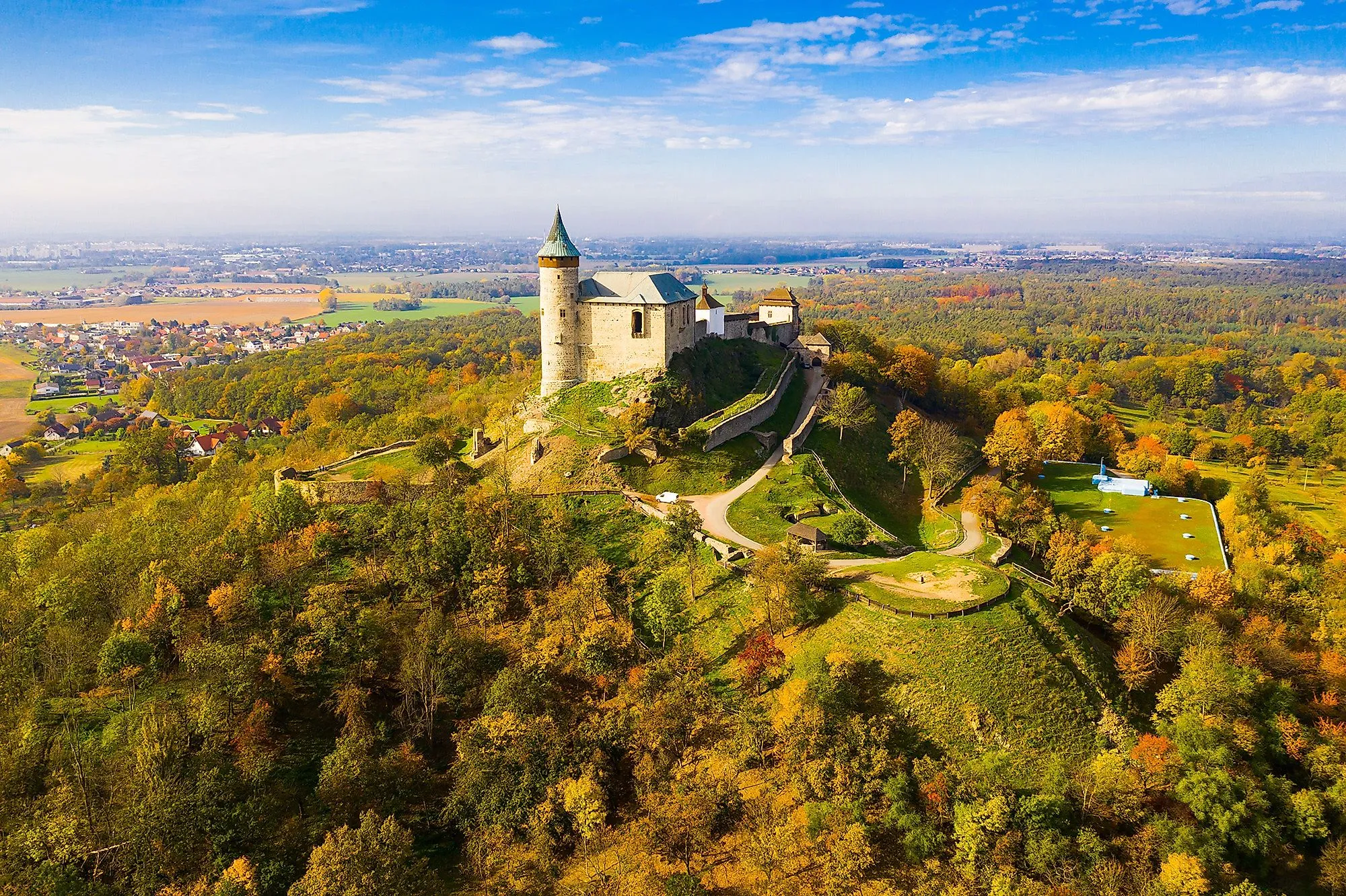 Luftaufnahme der Burg Kunětická Hora bei Pardubice, umgeben von herbstlichen Wäldern.