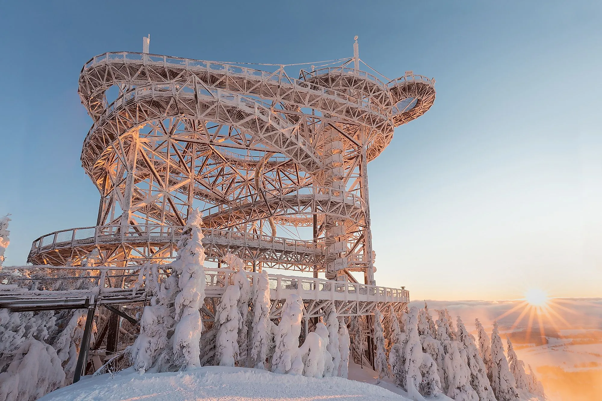Sky Walk de Dolní Morava en hiver, enneigé et illuminé au coucher du soleil.